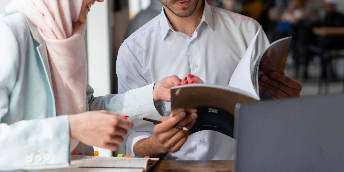Small business owners or startup team members brainstorming ideas together in a casual coffee shop setting, demonstrating budget-conscious collaboration.