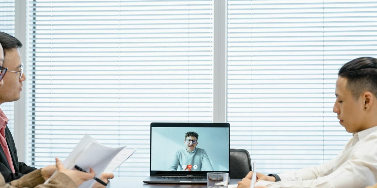 A diverse group of remote team members engaged in a video conference, demonstrating effective virtual communication strategies.
